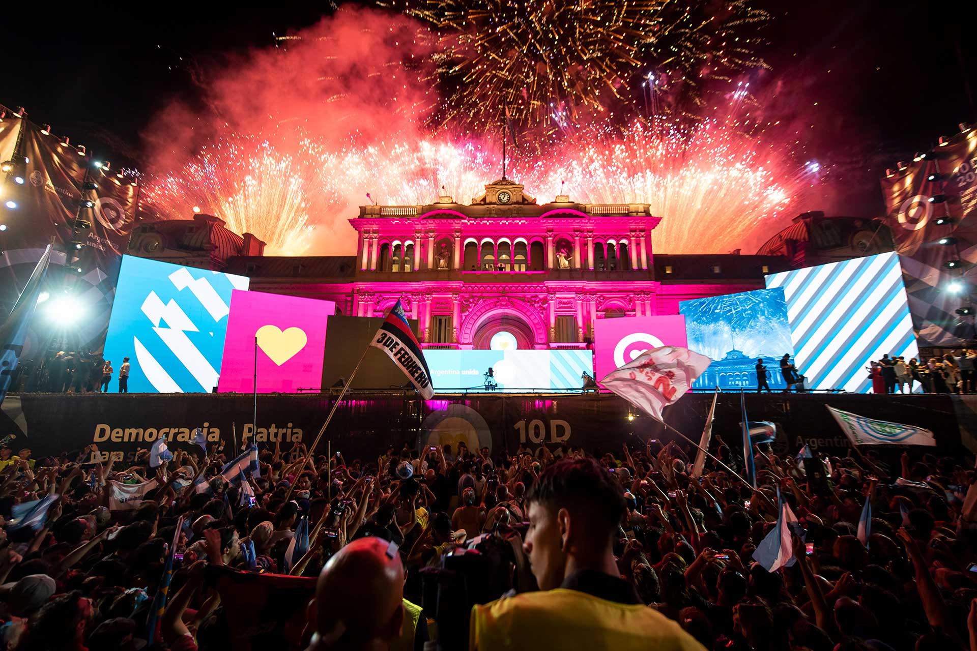 Fotografia de militantes observando los fuegos artificiales detrás de la 'Casa Rosada' durante los festejos del triunfo electoral por parte del 'Frente de Todos' en las elecciones presidenciales del año 2019