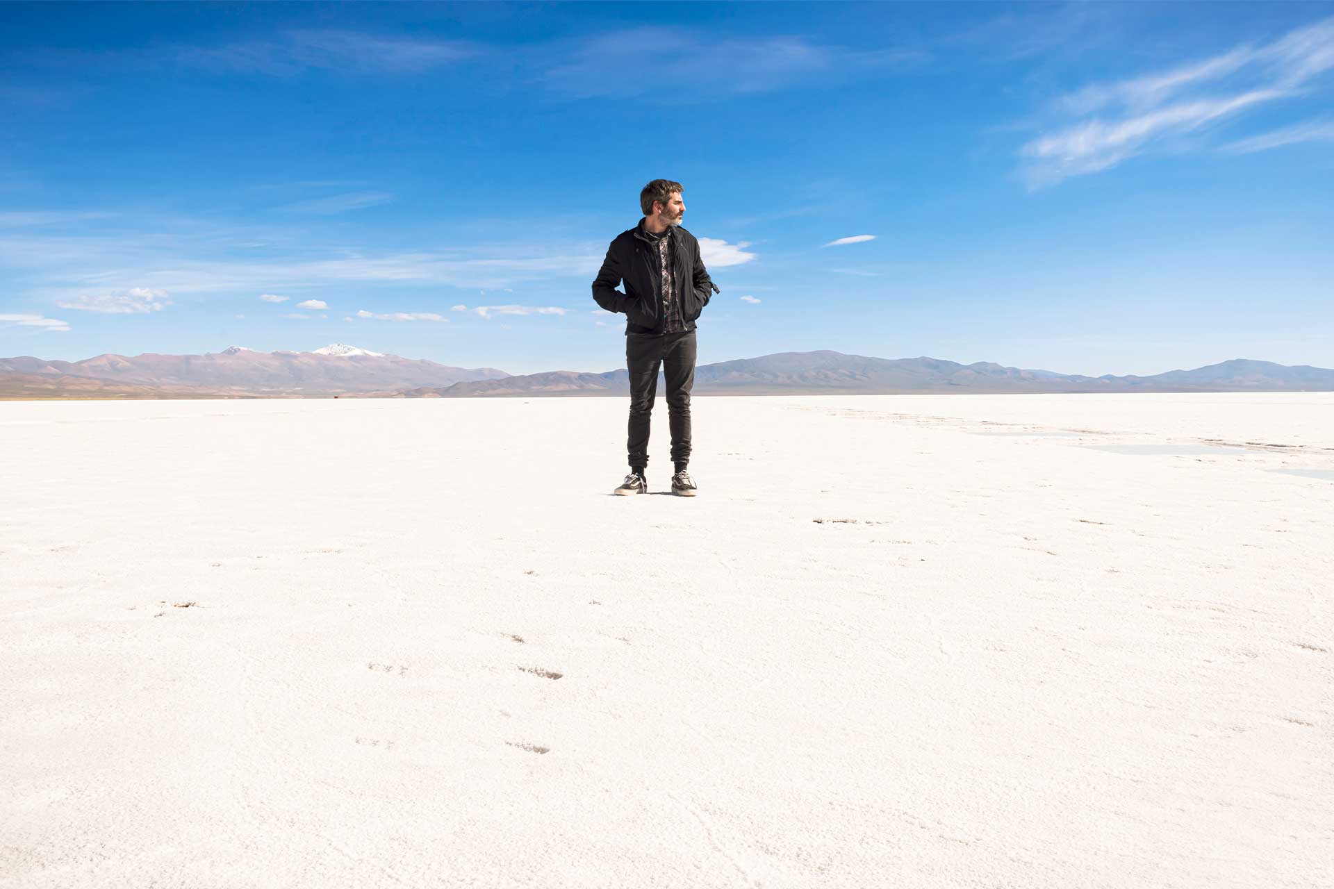 Solitario. Retrato fotográfico de un hombre parado en el centro de un Salar. Salar Grande, Jujuy, Argentina