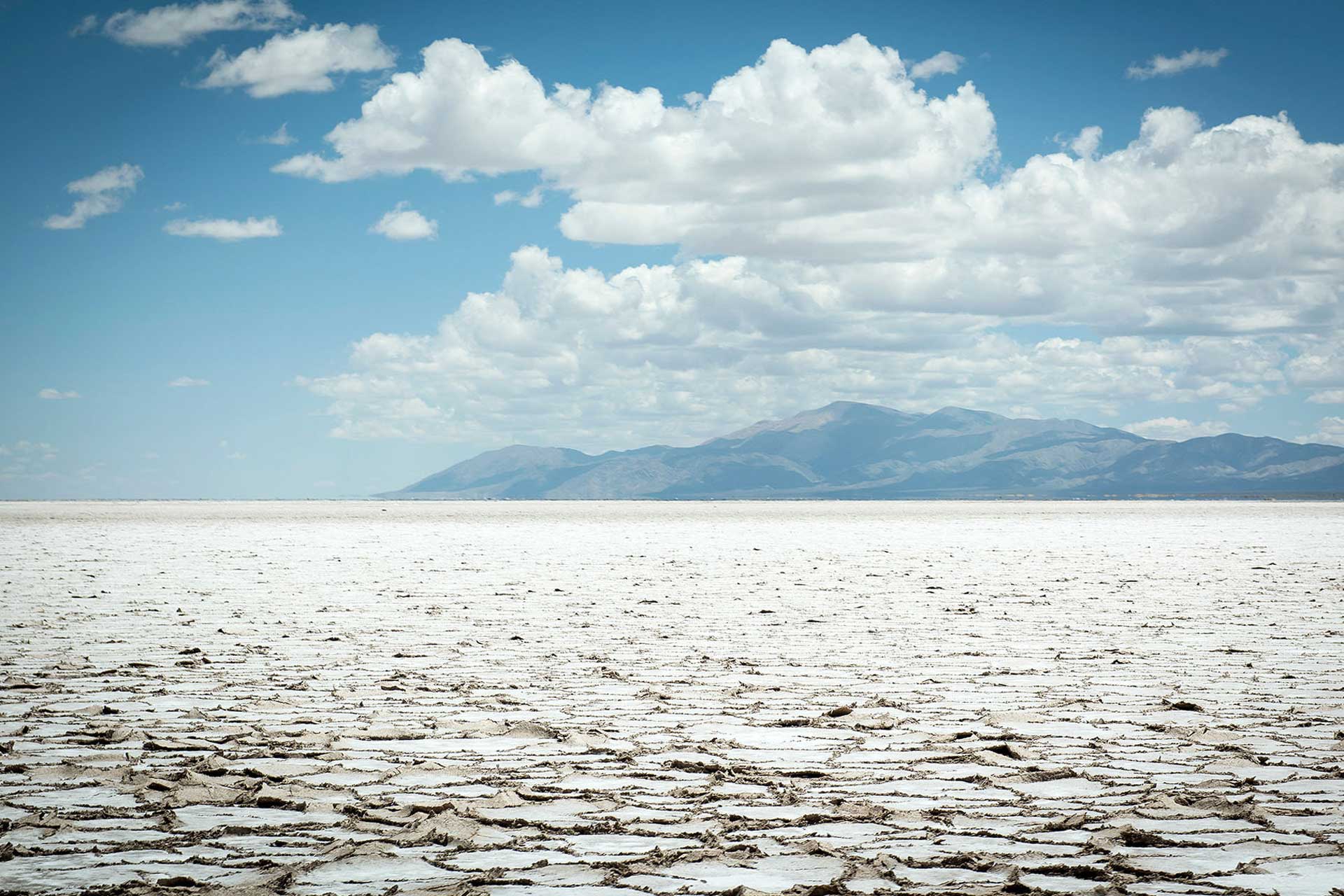 Fotografía de la inmensidad de las Salinas Grandes, Jujuy, Argentina. De fondo y muy alejadas se observa cordón montañoso